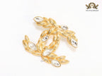 Twin C brooch in matte gold and fancy cz