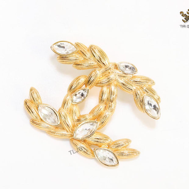 Twin C brooch in matte gold and fancy cz