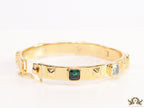Band style bracelet in gold plating with gold plated details and multi colour stones