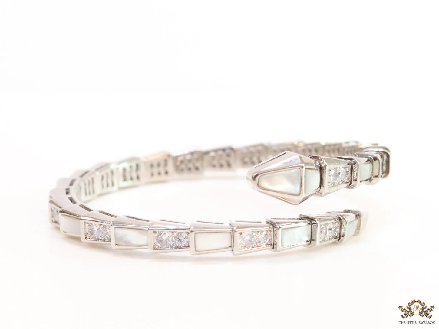 Open top platinum plated minimal snake bracelet with cubic zirconia stones and pearl white stones.