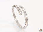 Open top platinum plated minimal serpentine bracelet with cubic zirconia stones and pearl white stones.