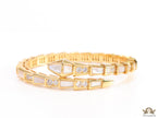 Open top gold plated minimal serpentine bracelet with cubic zirconia stones and pearl white stones.
