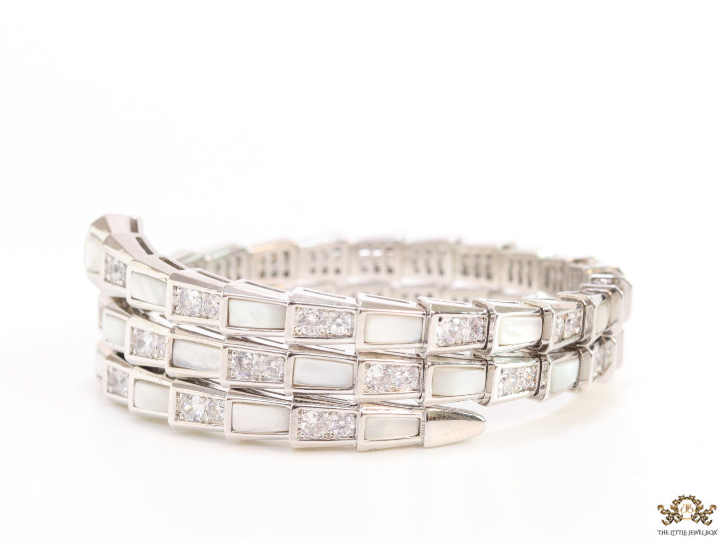 Triple line platinum plated minimal snake bracelet with cubic zirconia stones and pearl white stones.