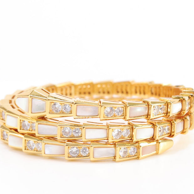 Triple line gold plated minimal serpentine bracelet with cubic zirconia stones and pearl white stones.
