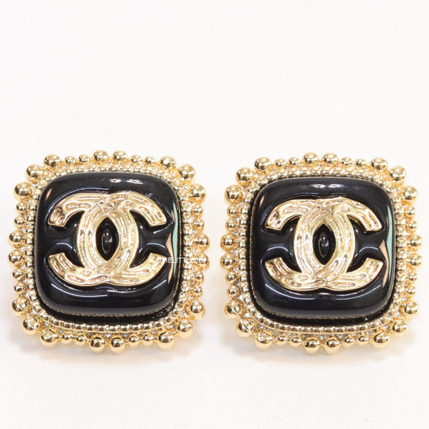 Square black and golden stud earrings with golden twin C motifs
