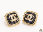 Square black and golden stud earrings with golden twin C motifs