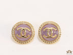 Twin C motif gold plated round studs on lilac acrylic base