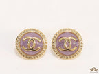 Twin C motif gold plated round studs on lilac acrylic base