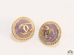 Twin C motif gold plated round studs on lilac acrylic base