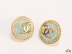 Twin C motif gold plated round studs on mint green acrylic base