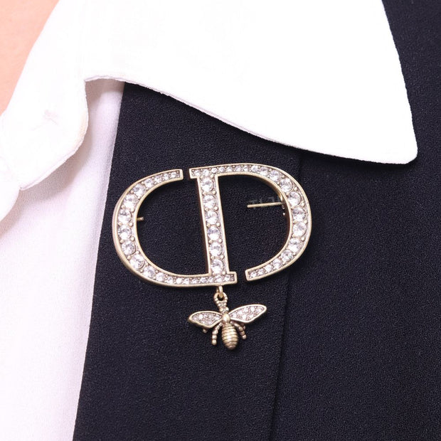 Alphabet C and D brooch in gold finish with dragonfly and cz