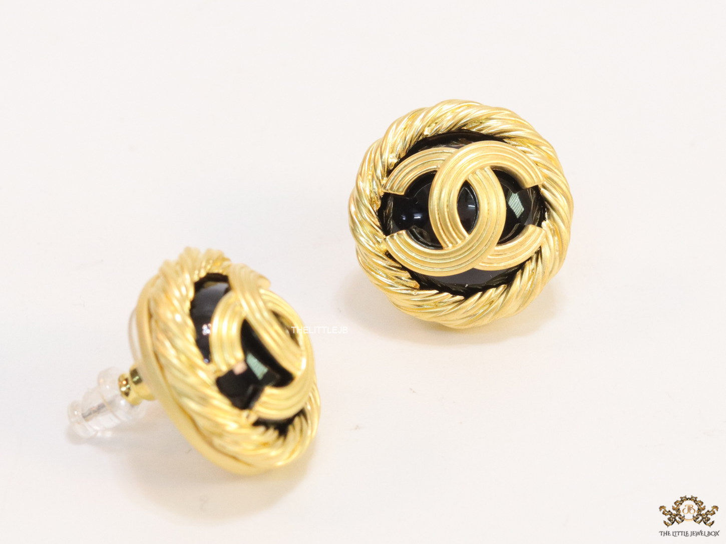 Twin C motif matt gold plated round studs on black base
