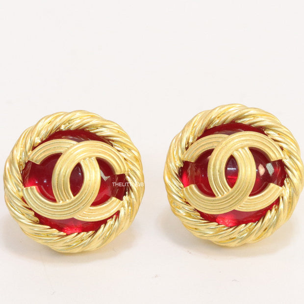Twin C motif matt gold plated round studs on red base