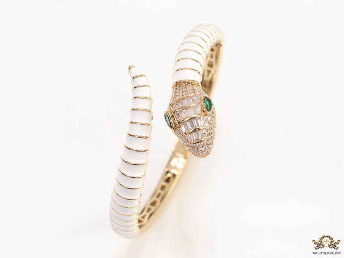 Top open serpentine bracelet in white enamel with  gold plated details and cubic zirconia stones head