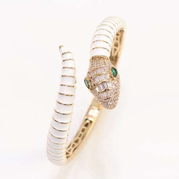 Top open serpentine bracelet in white enamel with  gold plated details and cubic zirconia stones head
