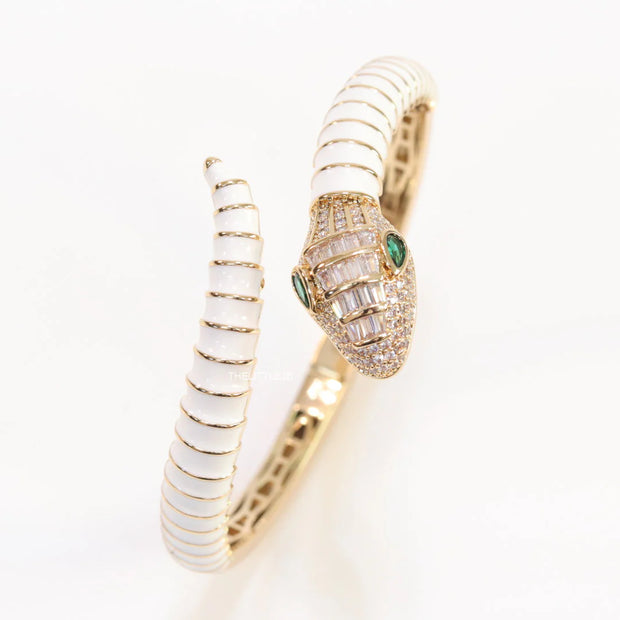 Top open serpentine bracelet in white enamel with  gold plated details and cubic zirconia stones head
