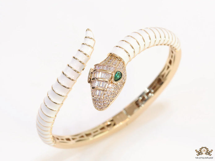 Top open serpentine bracelet in white enamel with  gold plated details and cubic zirconia stones head