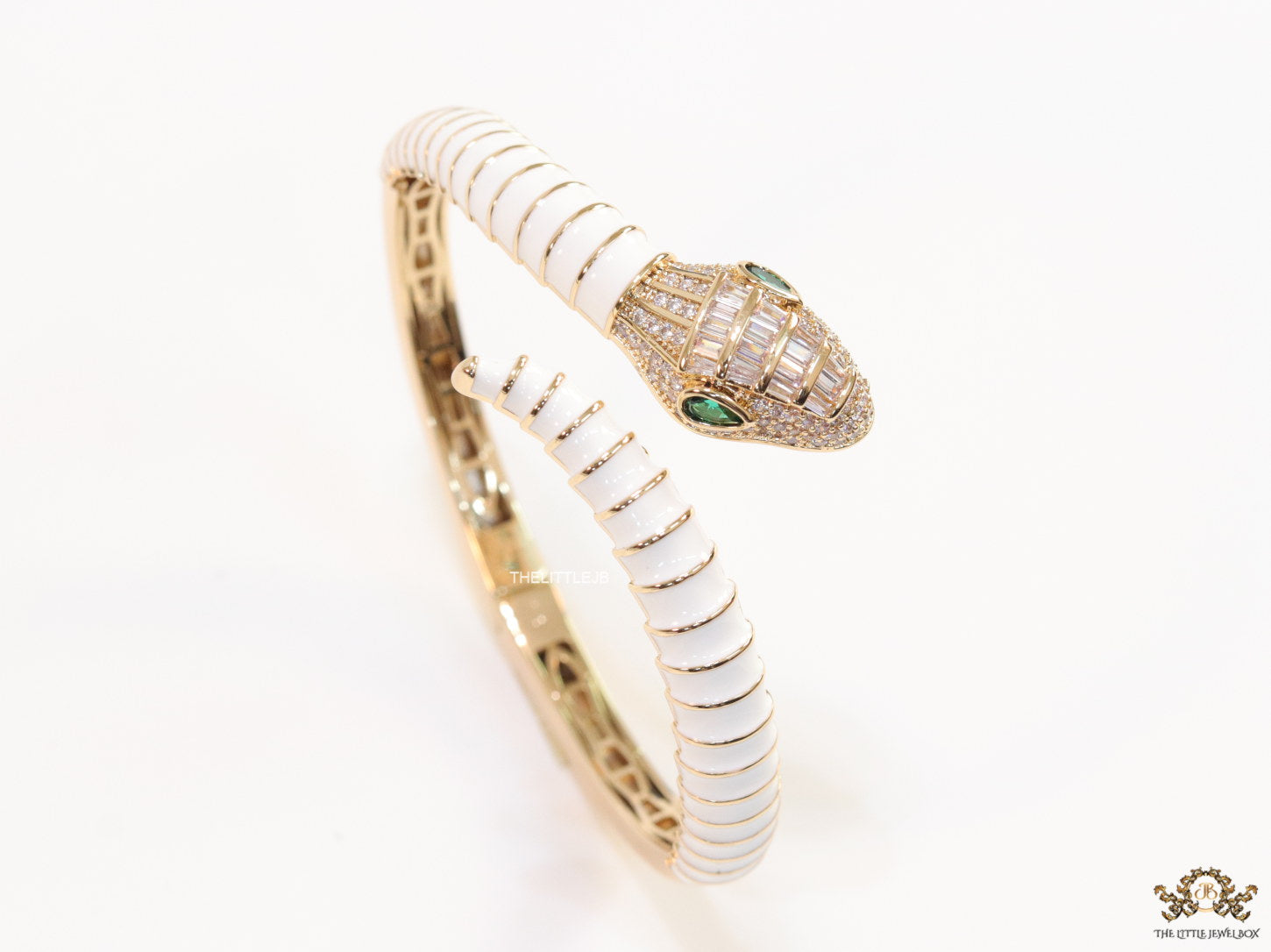 Top open serpentine bracelet in white enamel with  gold plated details and cubic zirconia stones head