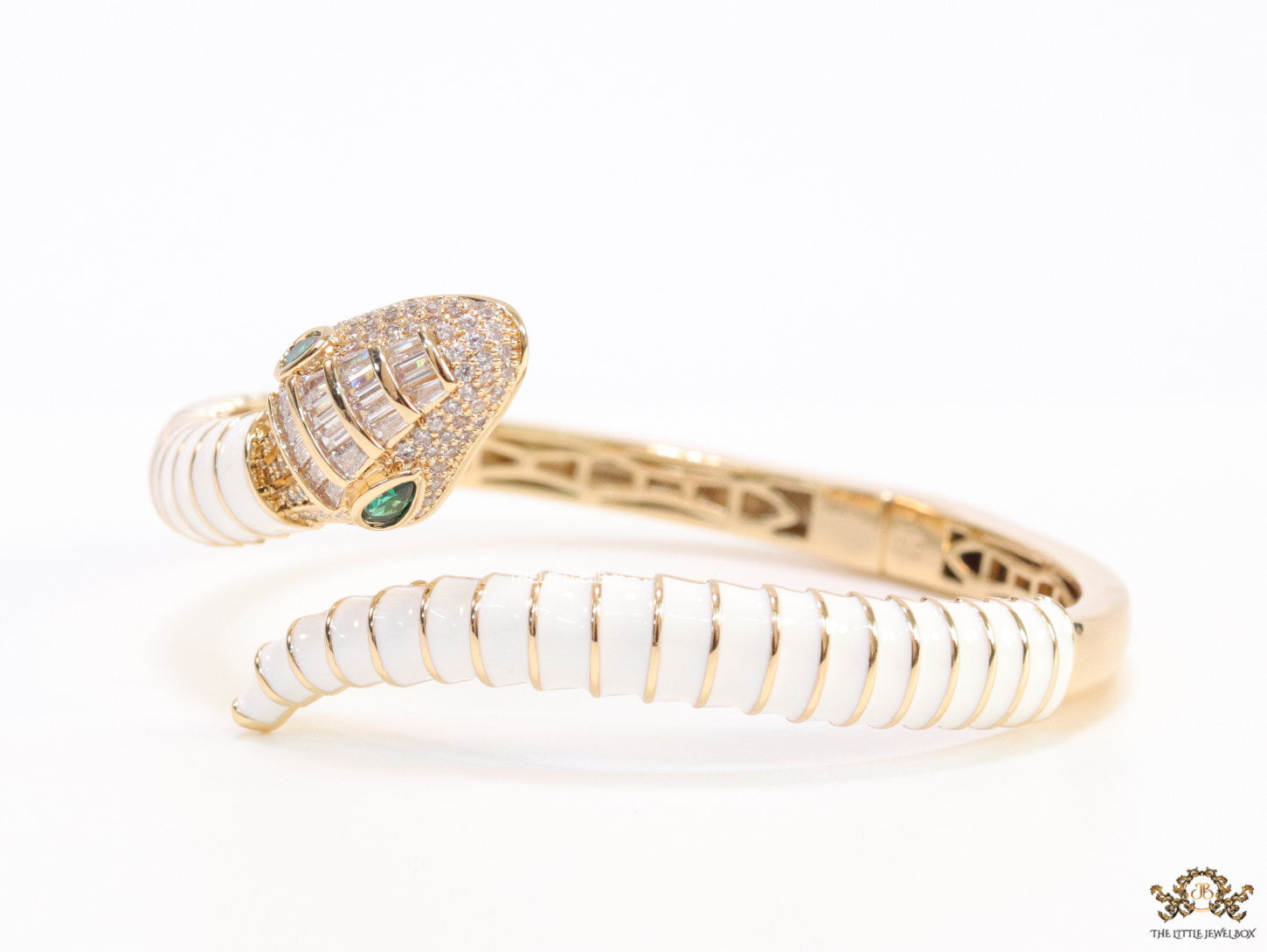 Top open serpentine bracelet in white enamel with  gold plated details and cubic zirconia stones head