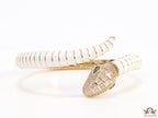 Top open serpentine bracelet in white enamel with  gold plated details and cubic zirconia stones head