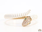 Top open serpentine bracelet in white enamel with  gold plated details and cubic zirconia stones head