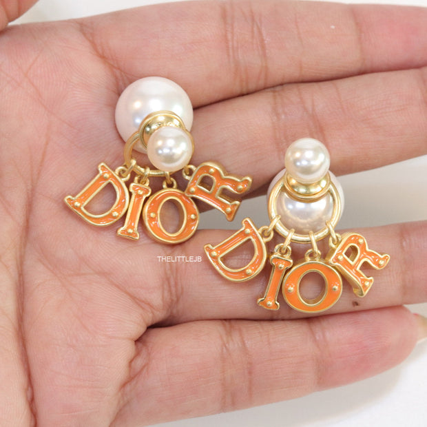 Pearl bomber earrings with golden and orange alphabet drop charms