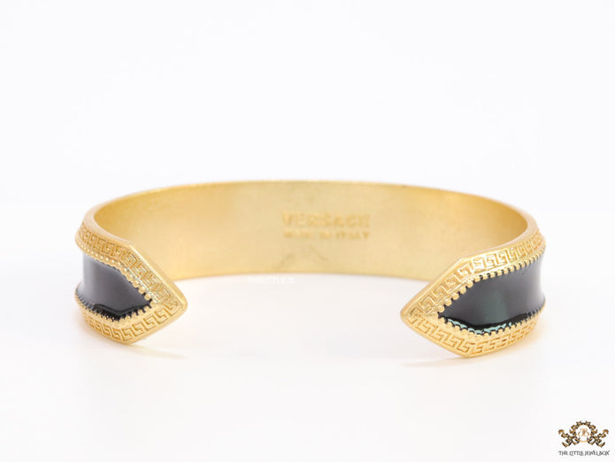 Band style black enamel bracelet with gold plated details and gold plated Medusa face motif