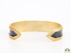 Band style black enamel bracelet with gold plated details and gold plated Medusa face motif