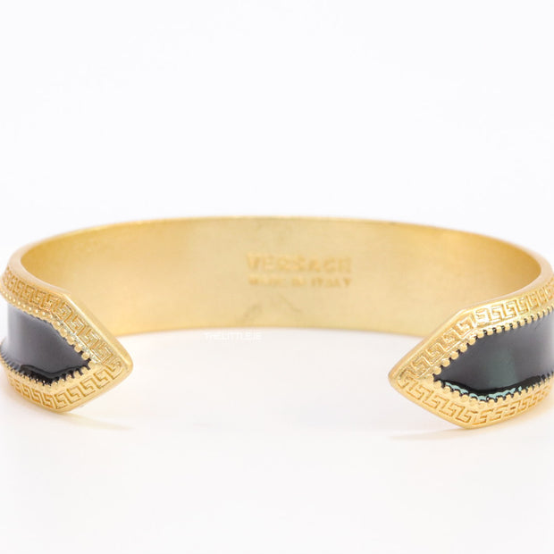 Band style black enamel bracelet with gold plated details and gold plated Medusa face motif