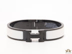 Premium collection band style bracelet in matt white with black metallic details and black T alphabet motif