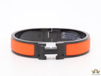 Premium collection band style bracelet in matt orange with black metallic details and black T alphabet motif