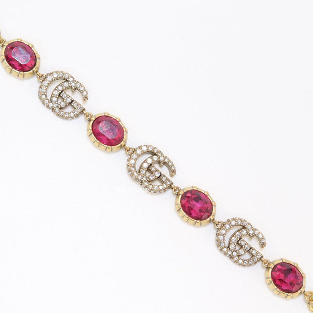 Gold plated linked chain bracelet with gold plated cubic zirconia stones twin G alphabet motifs and gold plated pink cubic zirconia stones