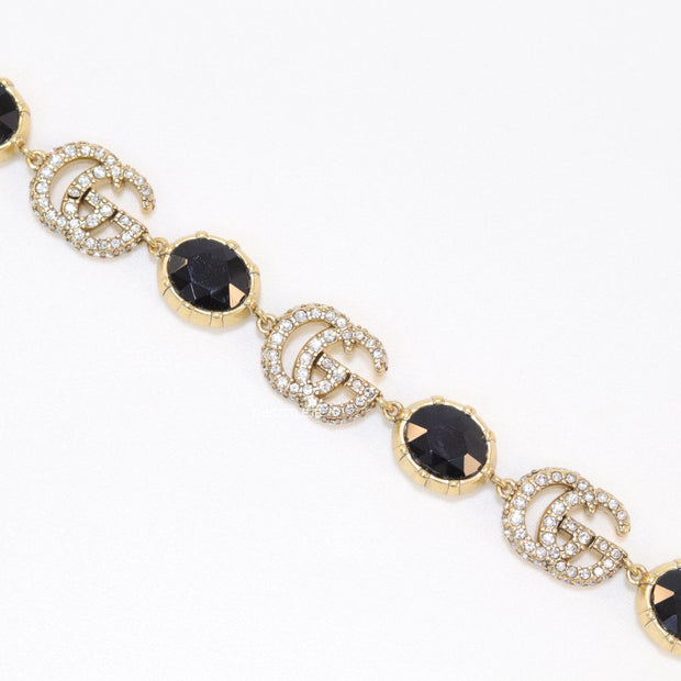 Gold plated linked chain bracelet with black stones and twin G alphabet motif