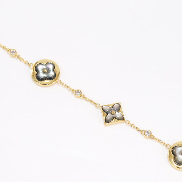 Sleek gold plated chain style bracelet with gold plated grey mother of pearl flower designs
