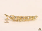 Golden feather brooch with fancy cz and twin C charm