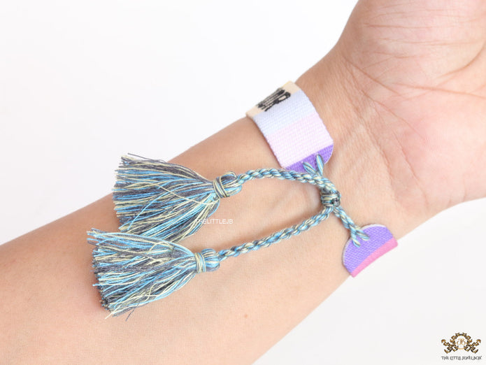 Adjustable multi color woven bracelet with black knitted alphabets and tassels