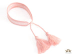 Adjustable pastel pink woven bracelet with knitted alphabets and tassels