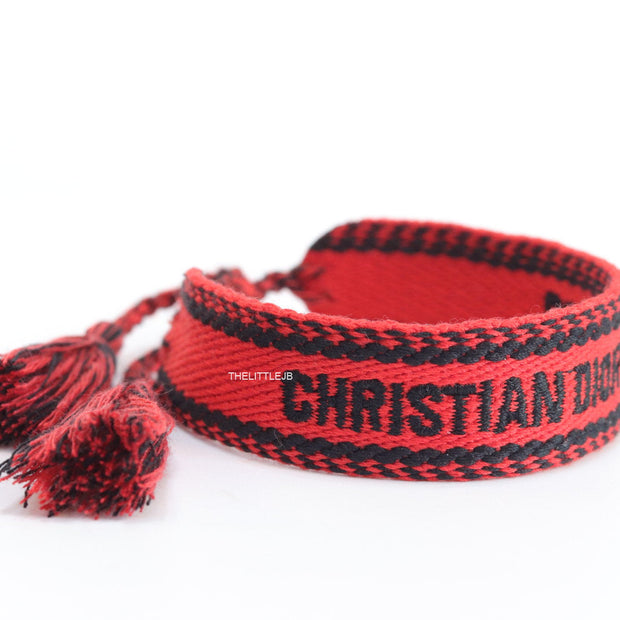 Adjustable red woven bracelet with black knitted alphabets and tassels
