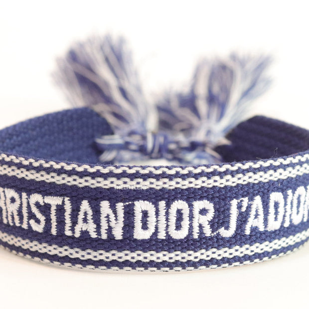 Adjustable blue woven bracelet with white knitted alphabets and tassels