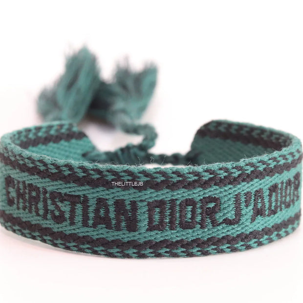 Adjustable green woven bracelet with black knitted alphabets and tassels