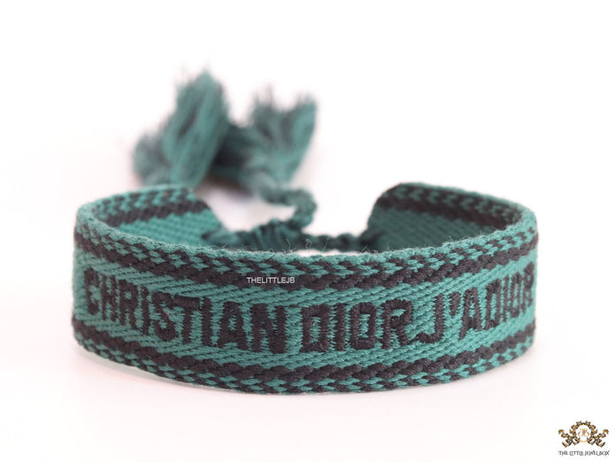 Adjustable green woven bracelet with black knitted alphabets and tassels