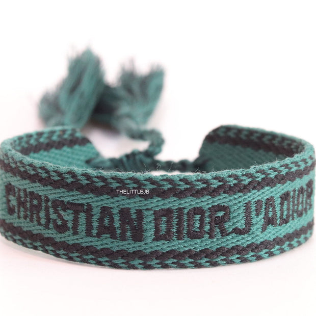 Adjustable green woven bracelet with black knitted alphabets and tassels