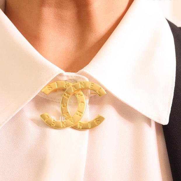 Double C embossed gold brooch