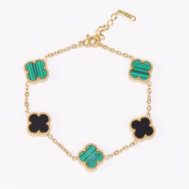 Golden chain bracelet with black and green clovers