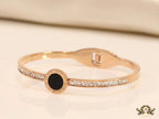Rose gold plated cz bracelet with roman numerals inscribed on black centre motif