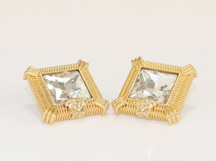Square solitaires in gold boundaries with medusa