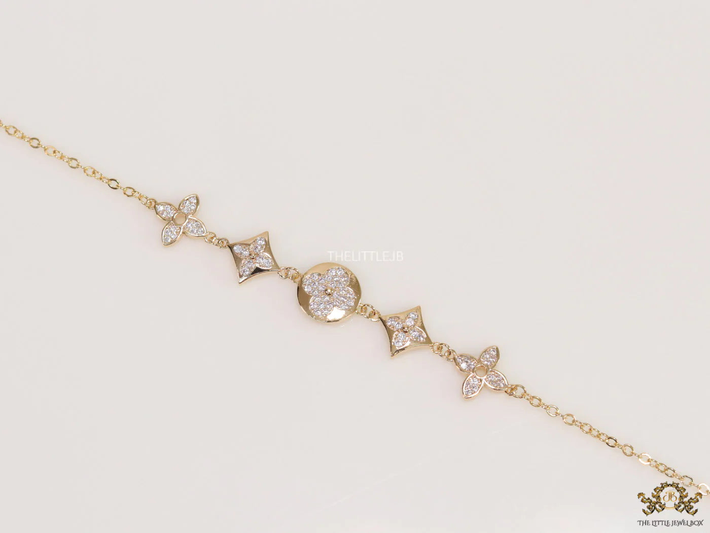 Gold plated chain bracelet with cz clovers and flowers