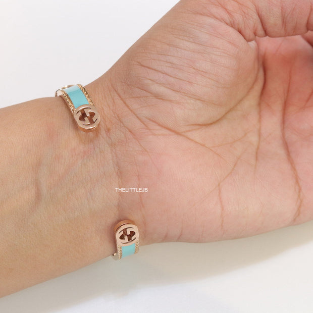 Blue and golden open band bracelet with twin G alphabet motifs