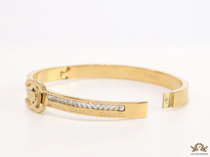 Gold plated bracelet with cz, inscribed alphabets and twin disc motif