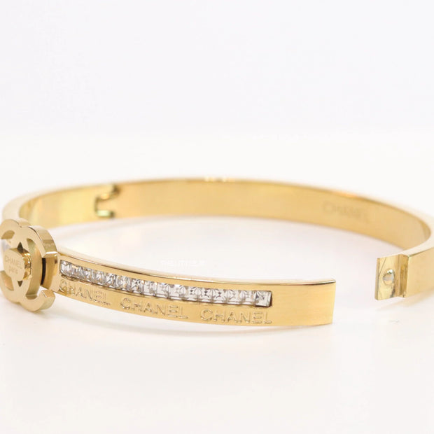 Gold plated bracelet with cz, inscribed alphabets and twin disc motif